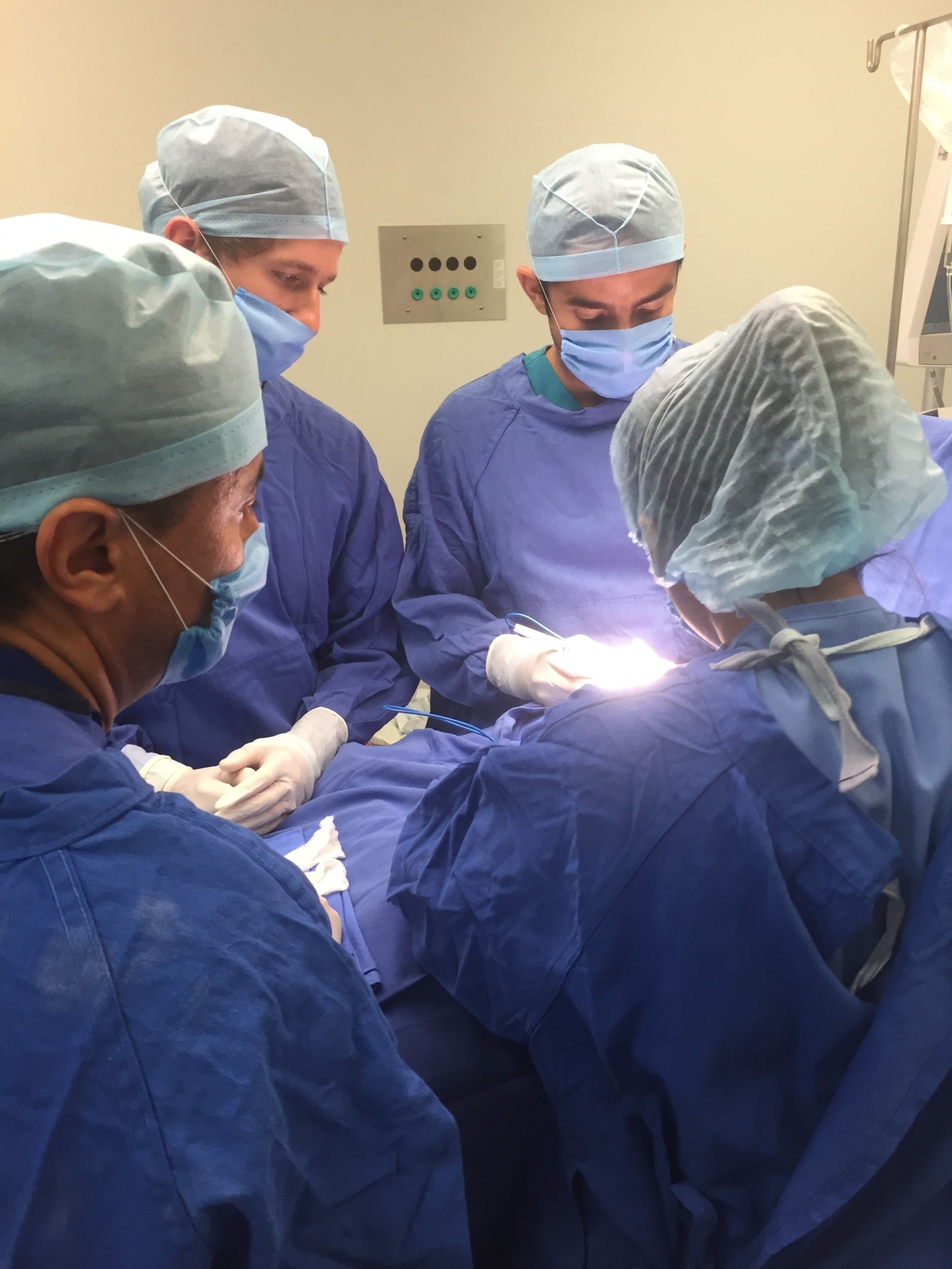 Surgical team in blue scrubs., doing surgery.