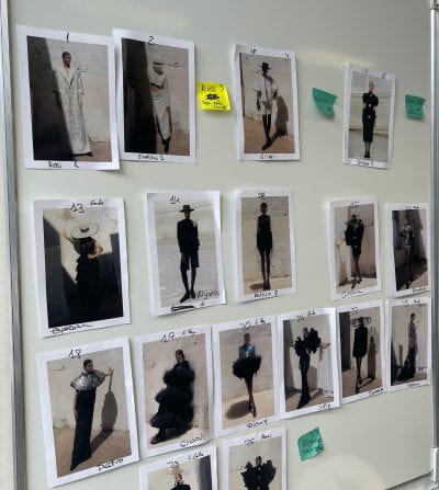 A wall of various fashion photos taped to a white background 