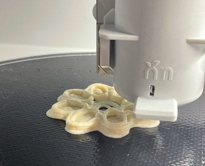 Image of food being extruded from a 3D printer