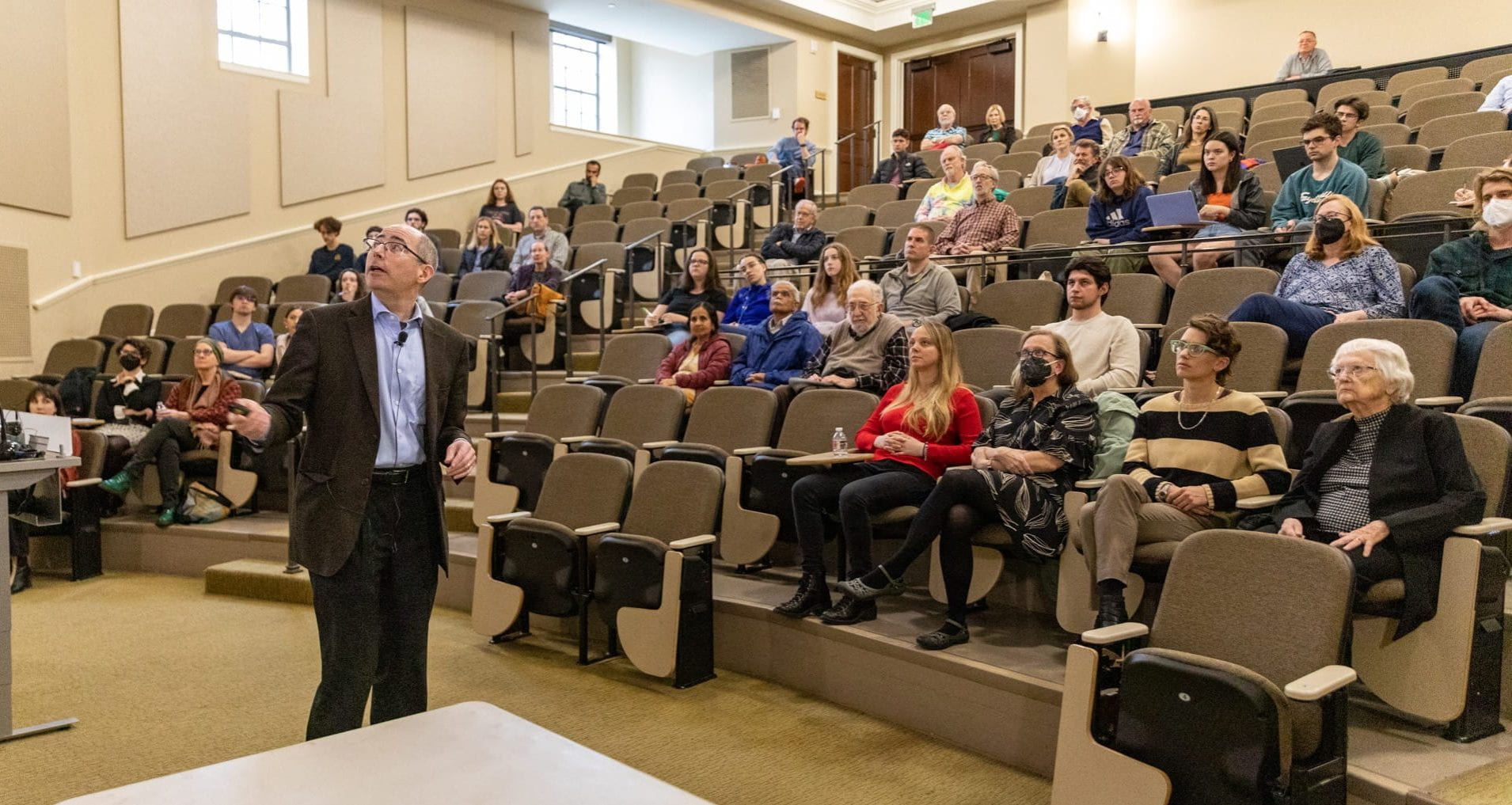 An auditorium with students seated looking at Dr. Kaiser as he lectures. 